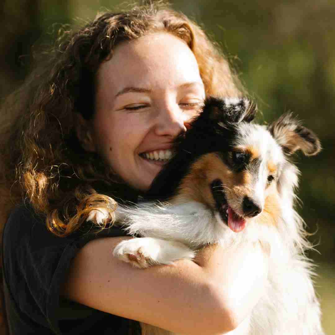 A person is holding a dog in their arms